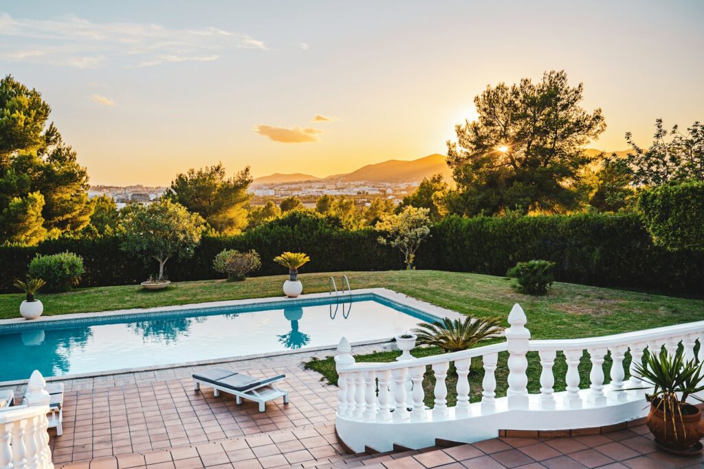 white outdoor pool near green trees during sunset